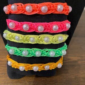 Neon macramé bracelets with pearl insets.